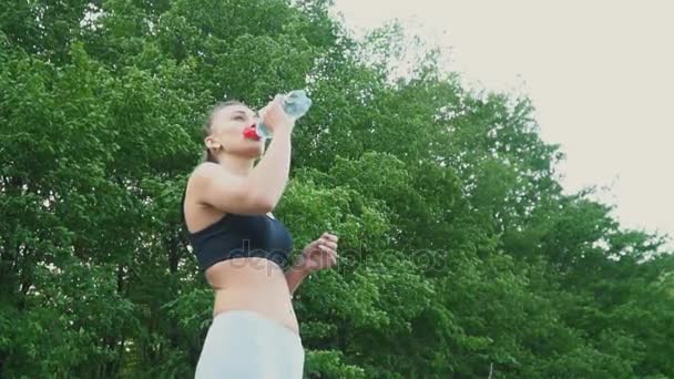 A lány egy üvegből iszik vizet. — Stock videók
