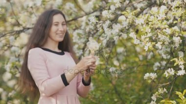 Dandelions üzerinde üfleme kız