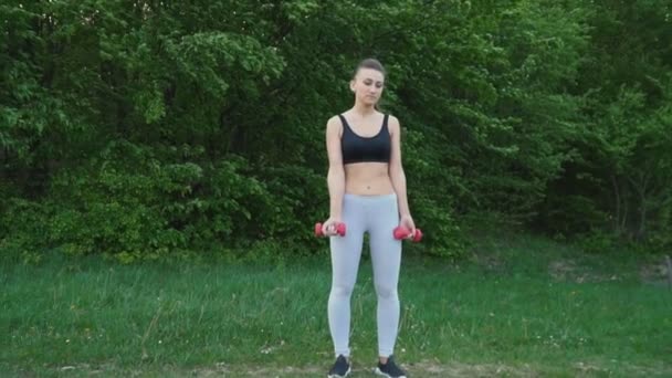 Flickan träning med en hantel — Stockvideo