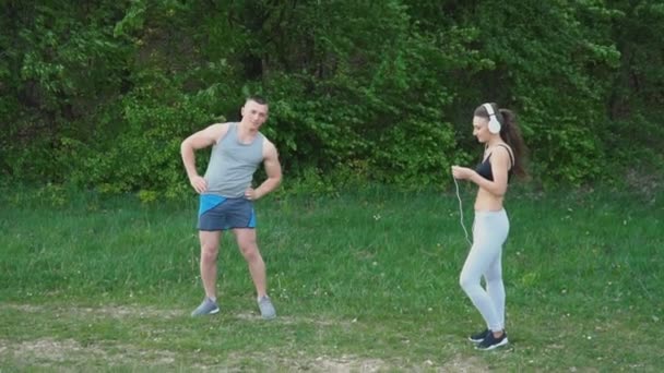 The guy does the warm-up while the girl is wearing headphones — Stock Video