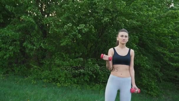 The girl is exercising with a dumbbell — Stock Video