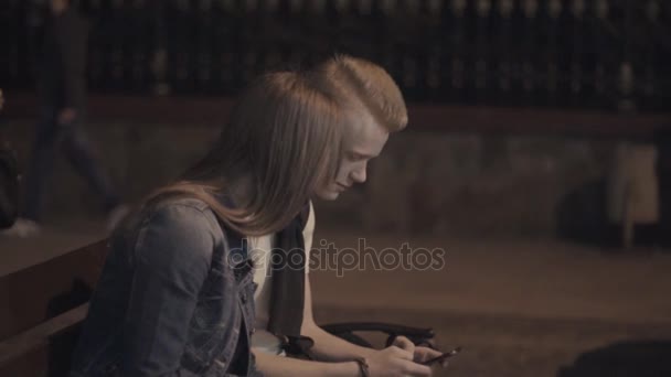 Het meisje gaat terwijl de man is kijken naar de telefoon — Stockvideo