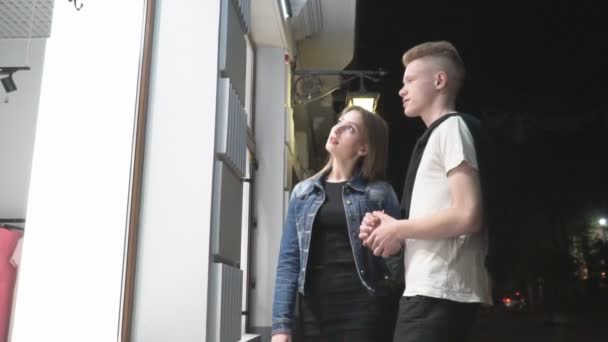 Пара стоит у витрины магазина — стоковое видео