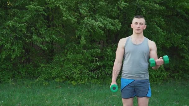 Chico haciendo ejercicio con pesas — Vídeos de Stock