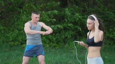 Kız kulaklık giyiyor iken adam ısınma yapıyor