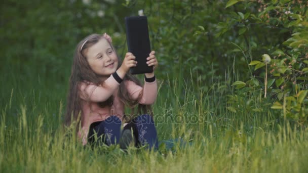 Little girl with a tablet in her hands — Stock Video