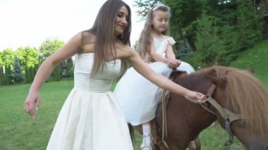 Anne kızı bir midilli üzerinde rulo.