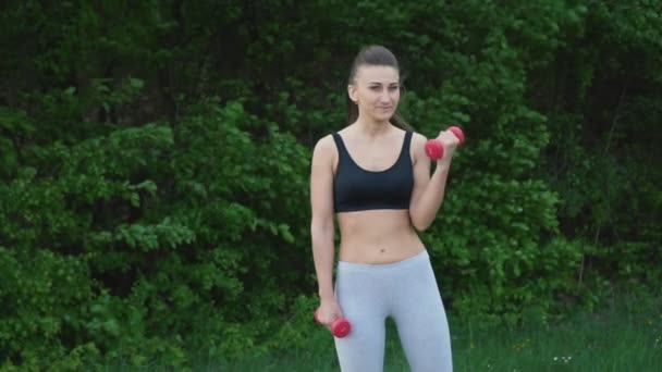 La chica está haciendo ejercicio con una mancuerna — Vídeos de Stock