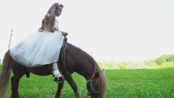 Moeder rolt haar dochter op een pony — Stockvideo