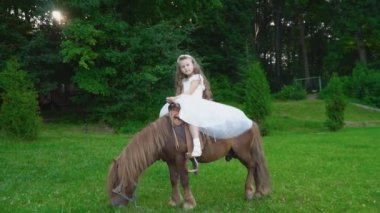 Küçük kız bir midilli sürme