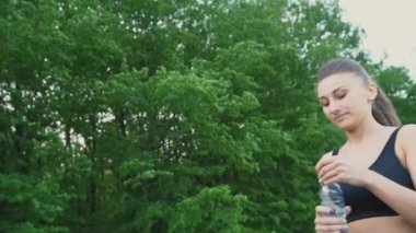 Kız şişeden su içiyor.