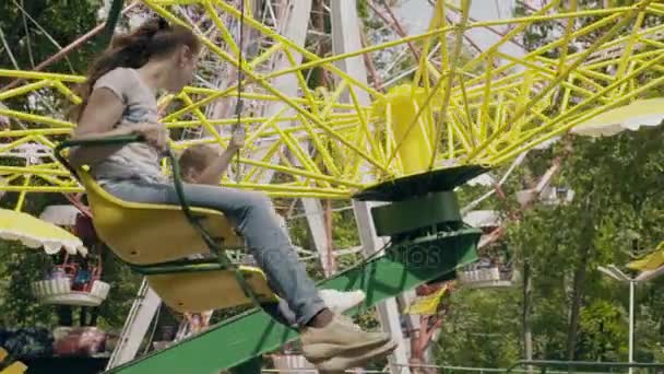 Moeder en dochter rijden de carrousel — Stockvideo