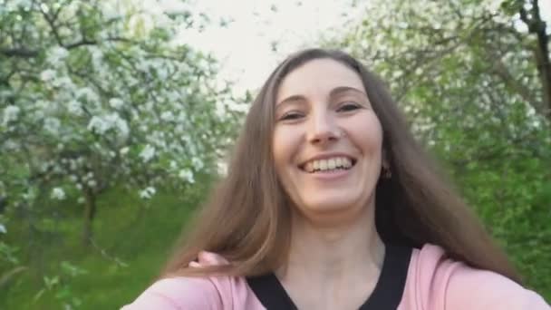Portret van een vrouw in een bloeiende tuin — Stockvideo