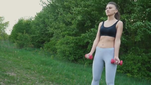 The girl is exercising with a dumbbell — Stock Video