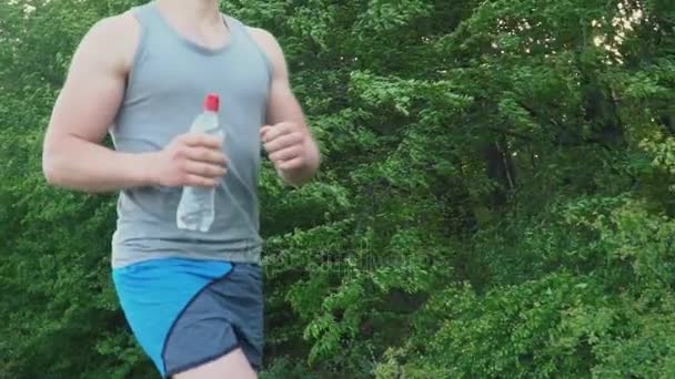 Бегущий парень с бутылкой воды — стоковое видео