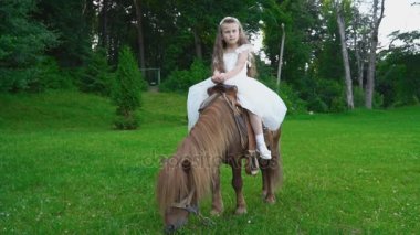 Küçük kız bir midilli sürme