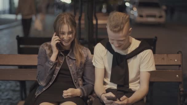 Man met een meisje op zoek in telefoons — Stockvideo