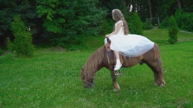 Küçük kız bir midilli sürme