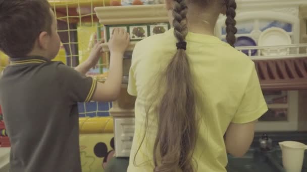 Діти грають з маленькими кухонними меблями — стокове відео