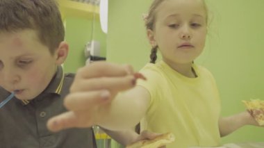 Çocuklar pizza yer.