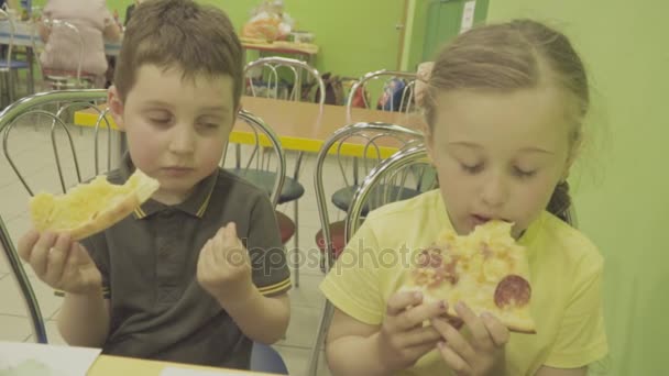 Kinderen eten pizza. — Stockvideo