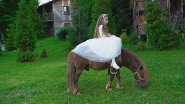 La niña está montando un pony. — Vídeos de Stock