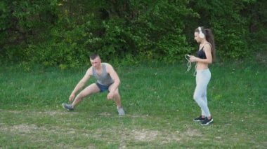 Kız kulaklık giyiyor iken adam ısınma yapıyor