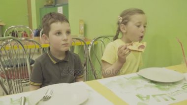 Çocuklar pizza yer.
