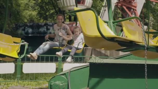Moeder en dochter rijden de carrousel — Stockvideo