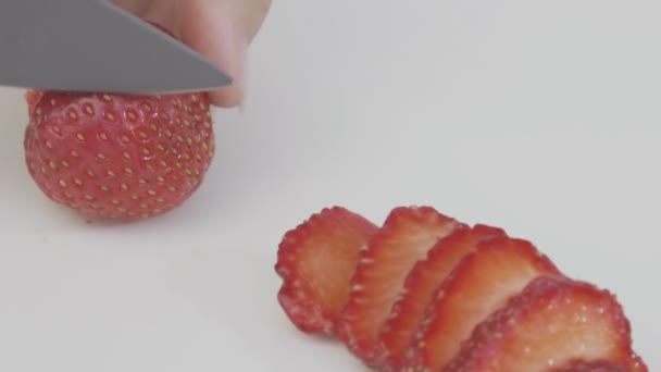 Skär jordgubbar med en kniv — Stockvideo