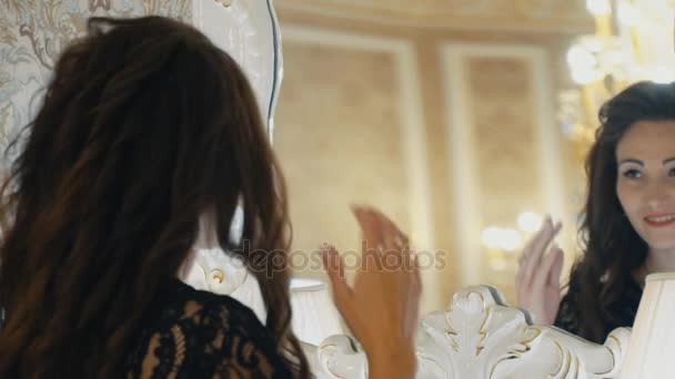 Frau sieht sich selbst durch den Spiegel an — Stockvideo