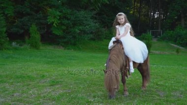 Küçük kız bir midilli sürme