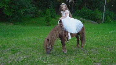 Küçük kız bir midilli sürme