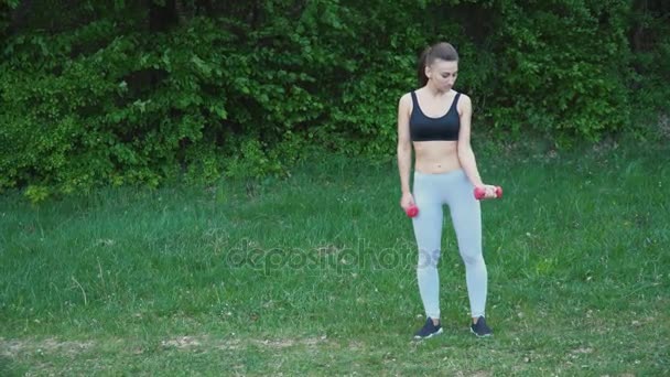 Девушка упражняется с гантели — стоковое видео