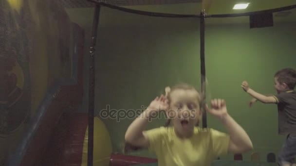 Barn hoppar på en studsmatta — Stockvideo