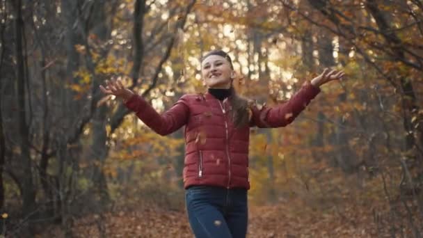 Woman tosses leaves — Stock Video