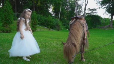 Kız midilli yanında yürüyor