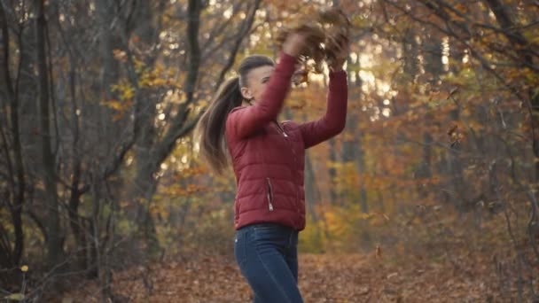 Woman tosses leaves — Stock Video