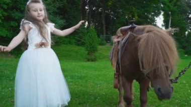 Kız midilli yanında yürüyor