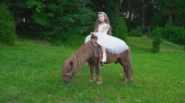 Küçük kız bir midilli sürme