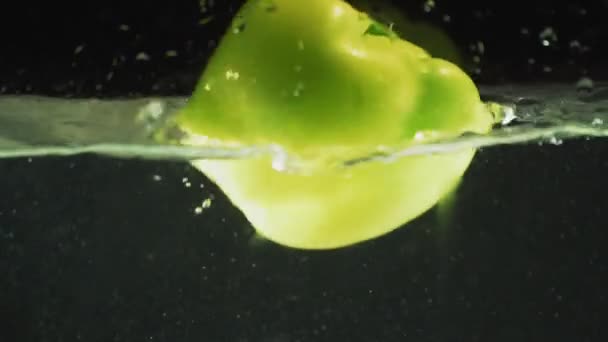 Groene peper druppels in het water — Stockvideo