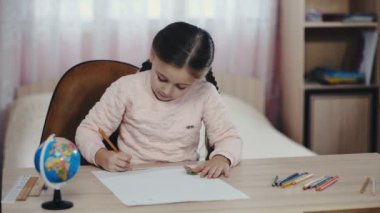 küçük kız bir şeyler çizer