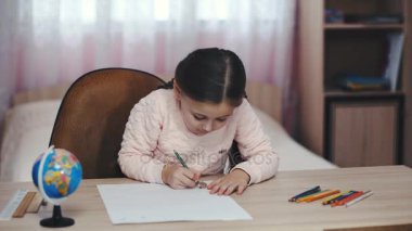 küçük kız bir şeyler çizer