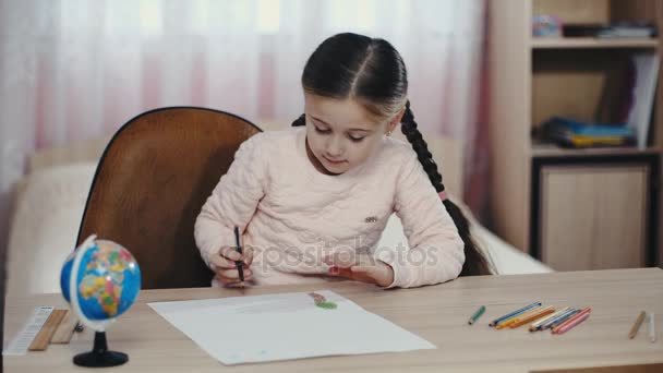Маленькая девочка что-то рисует — стоковое видео