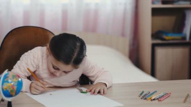 küçük kız bir şeyler çizer
