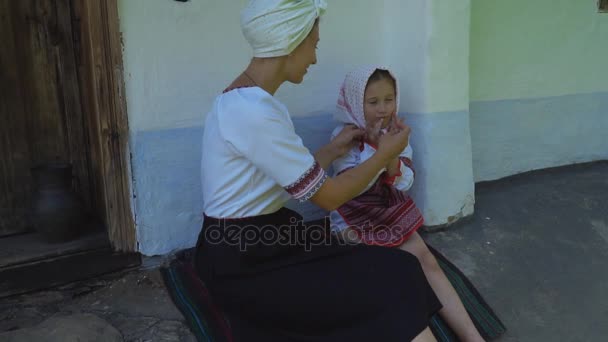 Madre e figlia sono seduti vicino alla casa — Video Stock