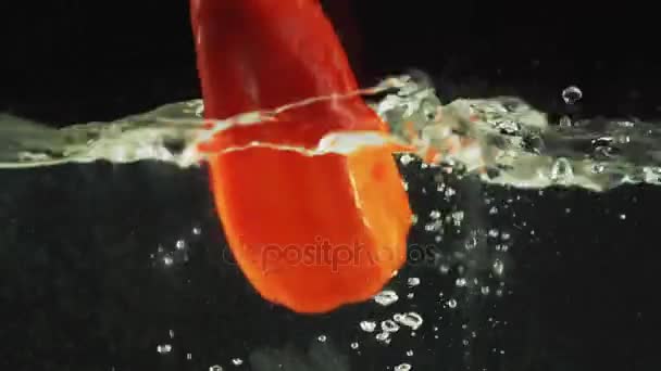 Pimenta vermelha cai na água — Vídeo de Stock