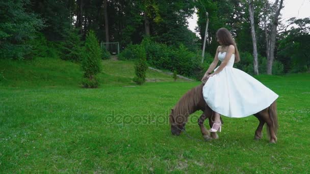 The girl is ride a pony — стоковое видео