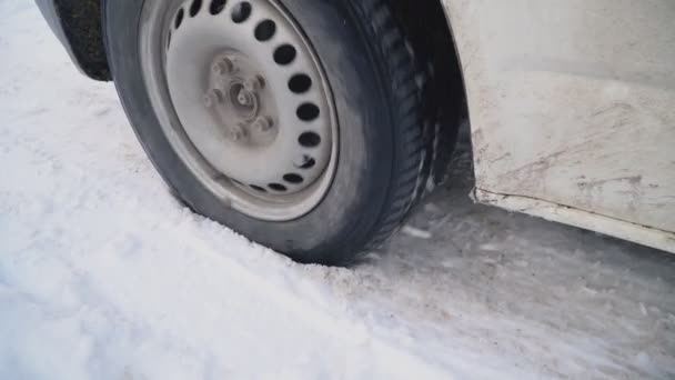 Колесо автомобиля на зимней дороге — стоковое видео
