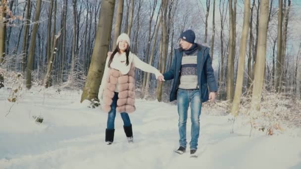 Ζευγάρι περπατά μέσα στο δάσος του χειμώνα — Αρχείο Βίντεο